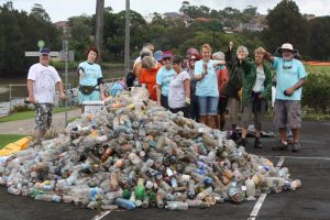 Mudcrabs members stand behind a huge pile of plastic bottles pulled out from the river